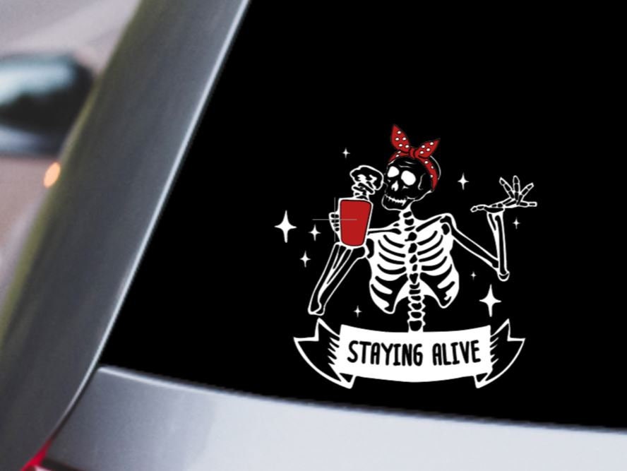 Staying Alive" Skeleton Vinyl Decal – Humorous Coffee drinking skeleton wearing a bandana - Fun Car and Laptop Decor Vinyl Decal